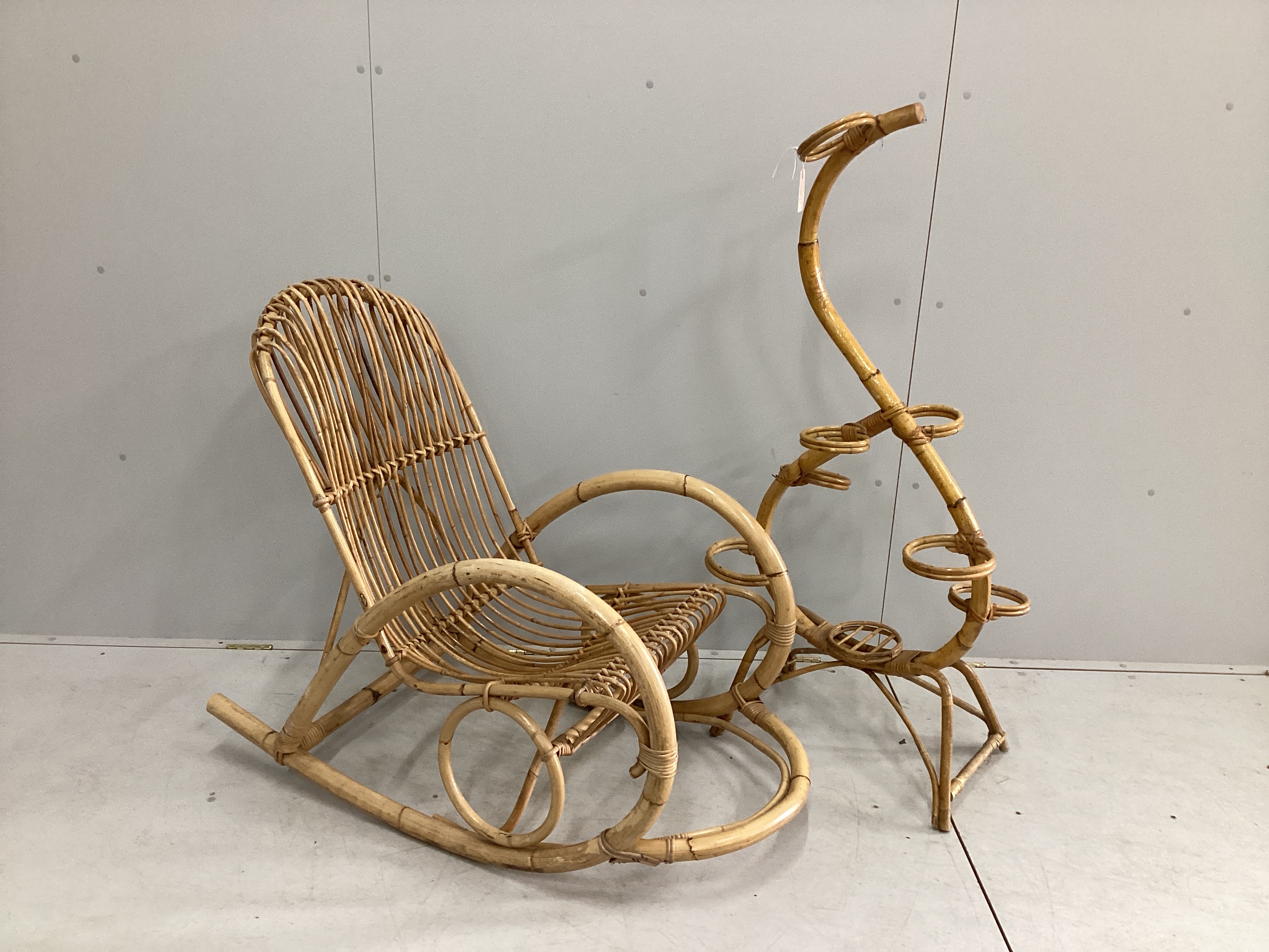 In the manner of Franco Albini, a caned bamboo rocking chair, width 58cm, depth 122cm, height 97cm, together with a pot stand